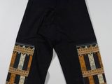 un gros plan sur un pantalon noir orné d'un motif sur le côté