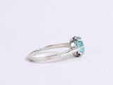 a close up of a ring with a green stone in it