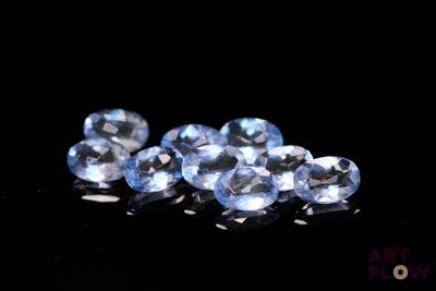 un gros plan sur un ensemble de saphirs bleus posés sur une surface noire