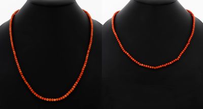 a pair of red coral necklaces on a mannequin
