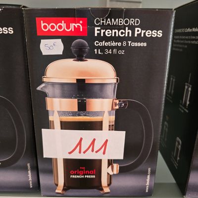 three boxes of french press coffee sit on a shelf in a store