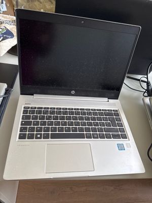 un ordinateur portable posé sur un bureau, à côté d'un clavier