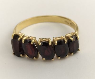 a close up of a gold ring with garnets on it