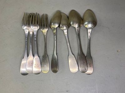 six fourchettes et cuillères sont alignées sur une table
