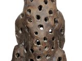 a brown bear statue with holes on it ' s face