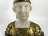 statue d'une femme vêtue d'une robe dorée et coiffée d'un chapeau