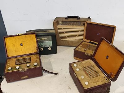 quatre valises posées sur une table où se trouve une radio