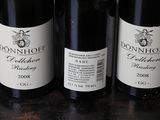 three bottles of wine are lined up on a table