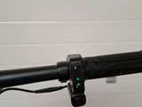 the handlebar of a bike with a green light on it