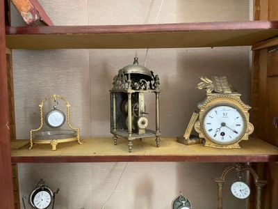 de nombreuses horloges différentes posées sur une étagère dans une pièce