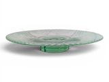 un gros plan d'une assiette en verre vert sur fond blanc