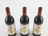 three bottles of wine sitting next to each other on a white surface
