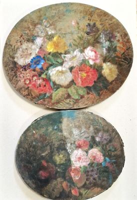 two plates with flowers painted on them sitting on a table