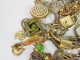 a pile of assorted jewelry on a white surface