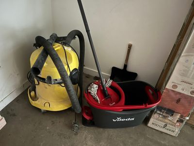 un aspirateur jaune et noir, un seau rouge et noir et un seau jaune et noir