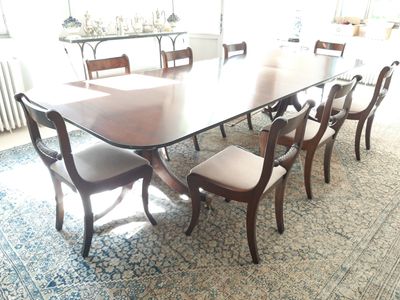 une grande table de salle à manger avec des chaises et un tapis