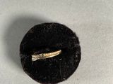 a gold ring with a diamond in it sitting on a piece of cloth