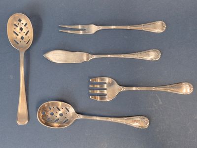 cinq cuillères en argent et deux cuillères en argent sur un fond bleu