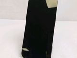 a black cell phone on a stand on a table