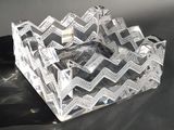 un cendrier en verre transparent posé sur une table avec un fond noir