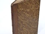 a brown book that is open on a white surface