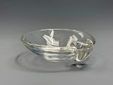 a glass bowl with a spoon in it sitting on a plate