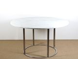 une photo d'une table en marbre blanc avec un piètement en métal