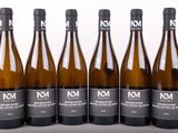 six bouteilles de vin sont alignées sur une table
