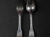two spoons and a fork on a black surface