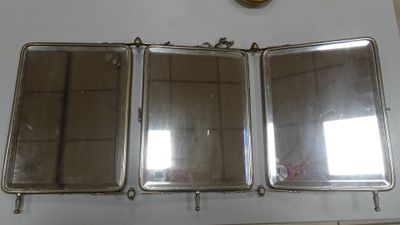 trois miroirs accrochés à un mur, avec une horloge en arrière-plan