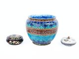 un vase bleu posé à côté d'une petite boîte sur une surface blanche