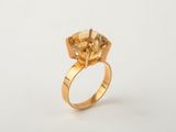 a close up of a gold ring with a yellow diamond on it