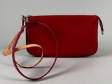 red leather wrist bag with strap and wrist strap on white background