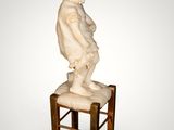 statue of a boy sitting on a chair with a small dog