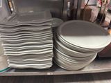 de nombreuses assiettes empilées sur une étagère dans un magasin