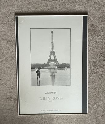 a black and white photo of a person standing in front of the eiffel tower