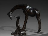 a bronze statue of a giraffe and a baby giraffe