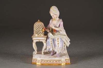 a figurine of a woman sitting on a chair