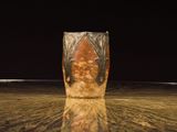 a vase that is sitting on a table with a black background