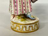 a figurine of a woman holding a basket of flowers