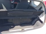 the back of a white car with its trunk open in a parking lot
