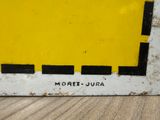 a picture of a yellow and black sign on a wooden table