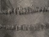 a close up of a piece of black fabric with fray edges