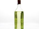 a bottle of green liquid sitting on a white surface