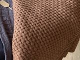 une couverture tricotée marron posée sur une chaise