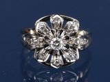 une image d'une bague ornée d'une fleur en diamant sur un fond bleu