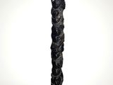 a tall black sculpture with a white base on a white surface