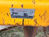 a close up of a yellow tractor with a chain on it ' s back