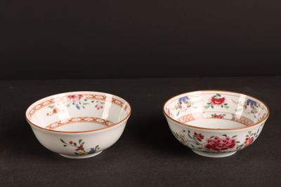 pair of chinese bowls with floral designs on them on a black surface