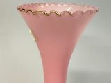 a pink vase with a gold rim on a table
